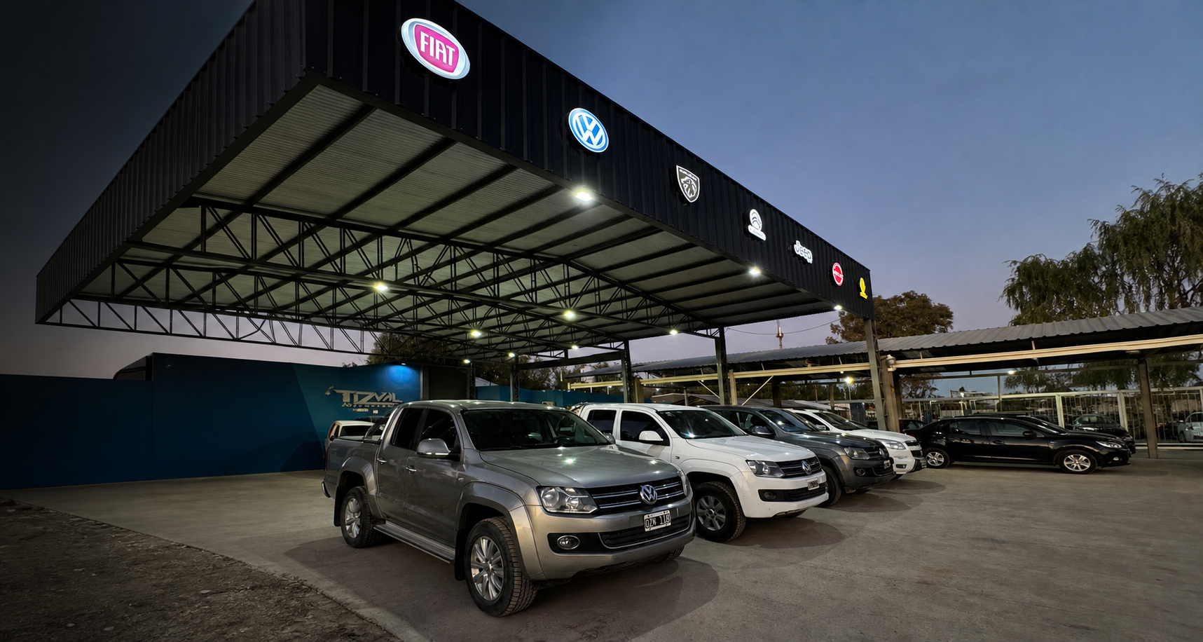 Vehículos exhibidos bajo el techo iluminado de Tizval Automotores